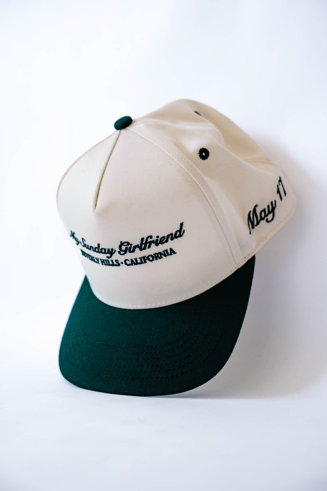 Two-tone cap with white top and forest green bottom on a white background