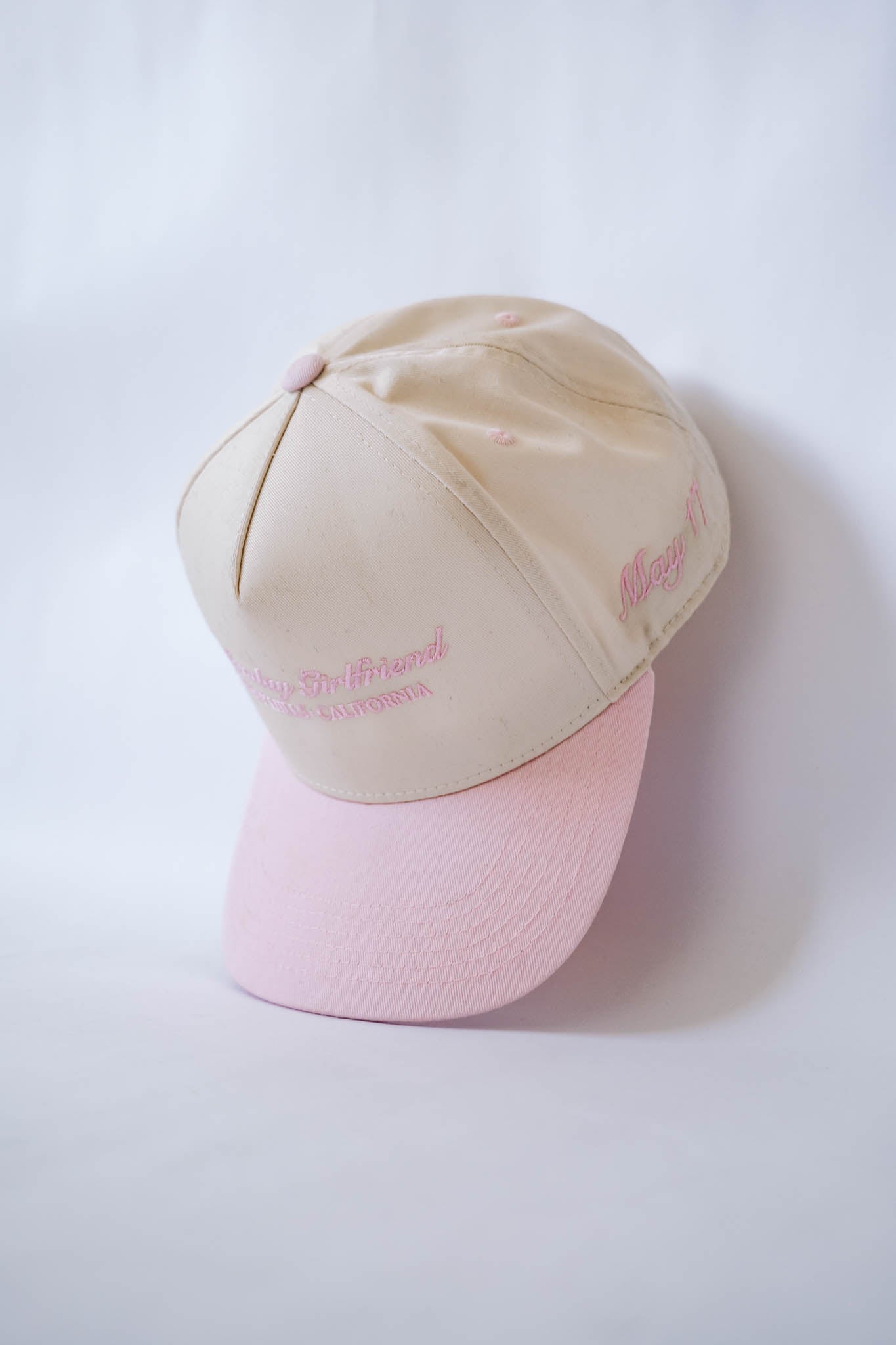 Two-tone beige and pink cap on a white background